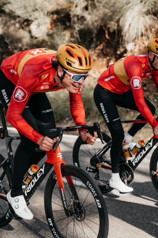 兩位身穿紅色車衣的車手在山路上騎乘 Ridley 公路車